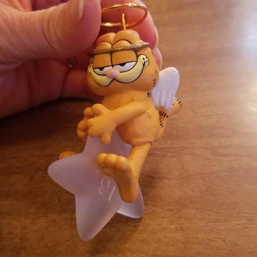 Vintage 1991 Garfield ornament. Angel Garfield is swinging on a star.